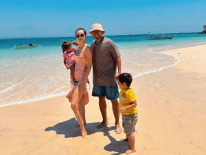 a man and woman with two children on a beach lombok